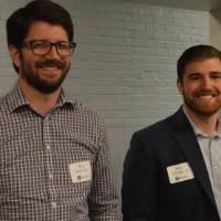 Two alumni smile for a photo at the Academic Major Fair.